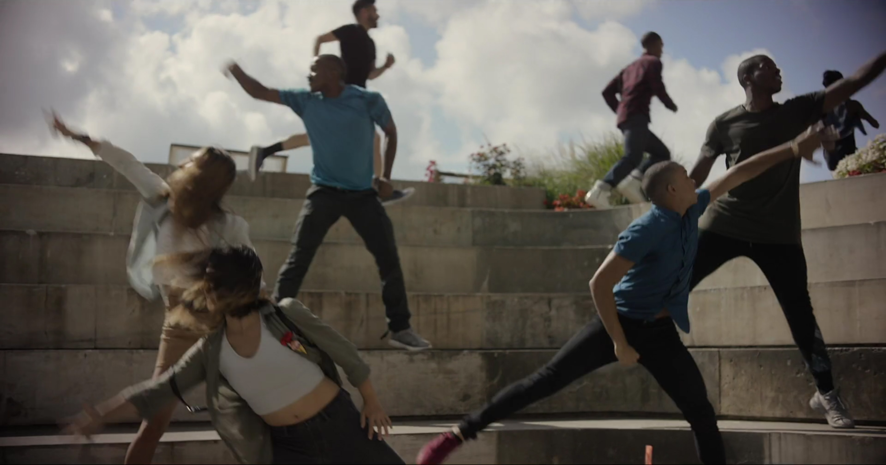 Three stills from The Mill’s teaser video for Vessel. Dancers dressed as typical New Yorkers dance in the morning sun on a set of gray stairs. Together, their bodies form the latticework in shadow of <i>Vessel</i>.